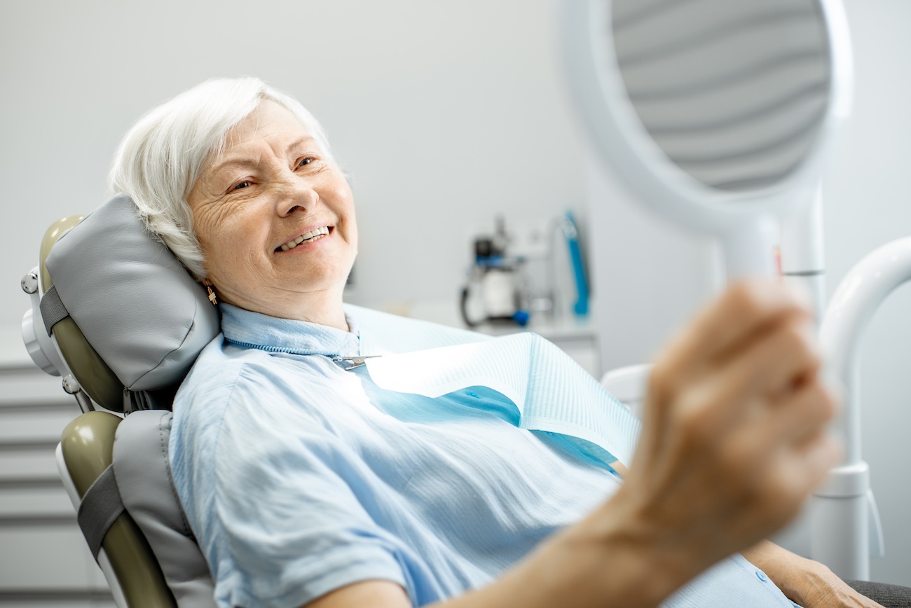 elderly woman smiling at dentist