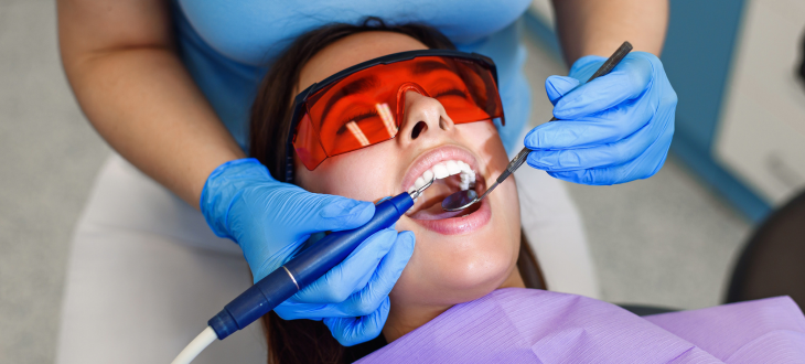 Woman with dental goggles on having teeth examined